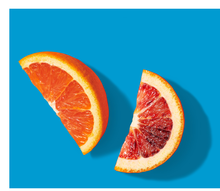 Two slices of citrus: one orange slice and one grapefruit slice