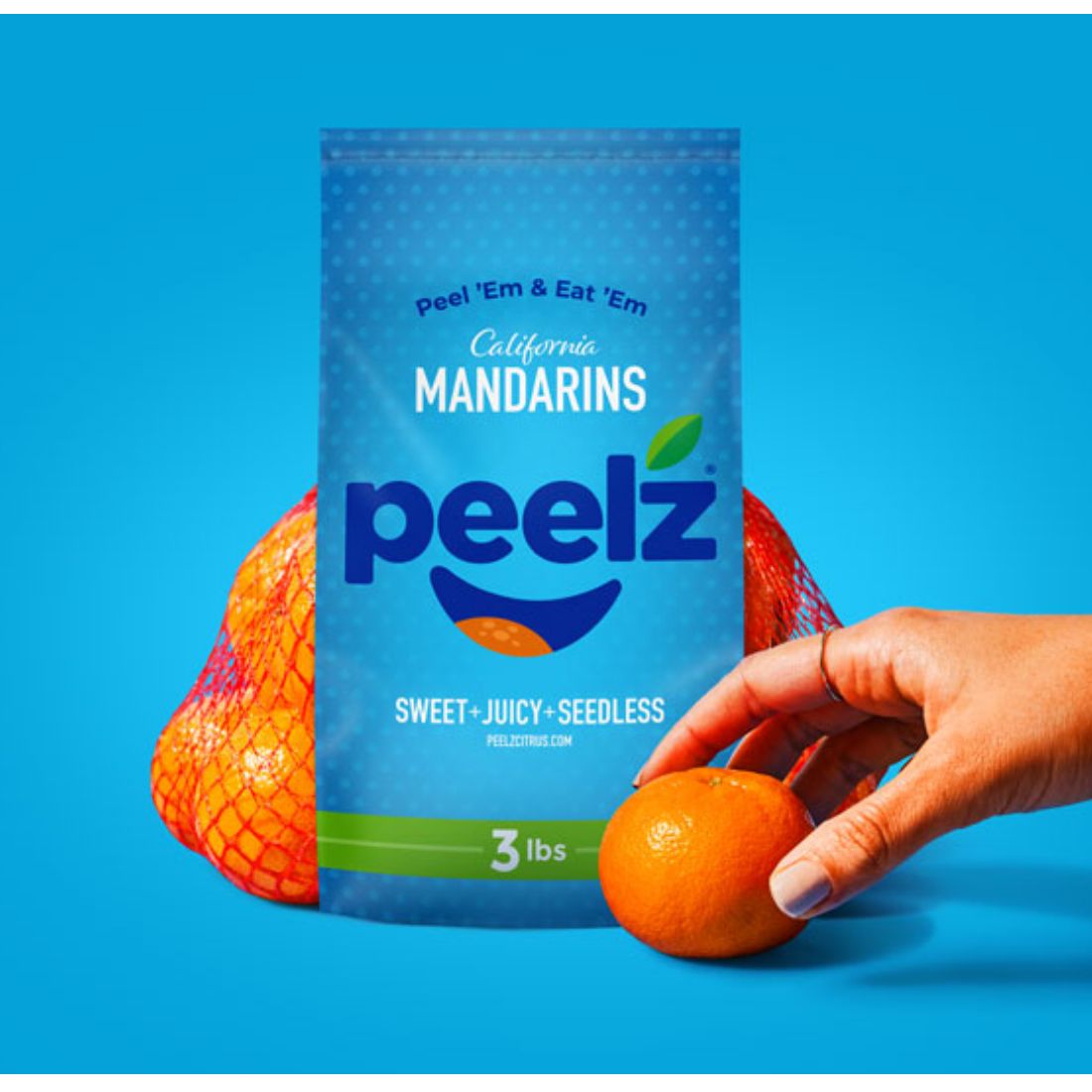 Peelz mandarins packed with a hand reaching for a mandarin sitting in front of the bag